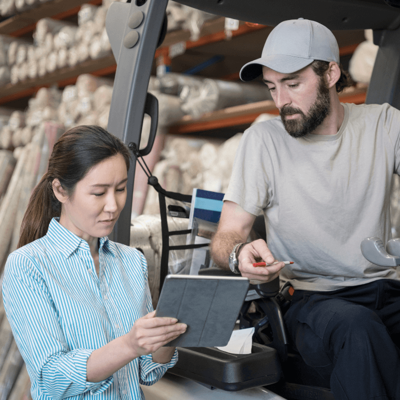 Male and female workers checking stock in a storeroom